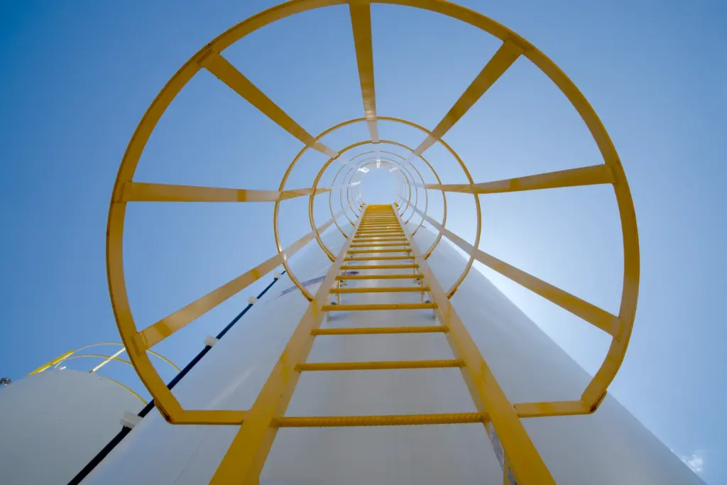 Looking up at a yellow ladder up at the sky.