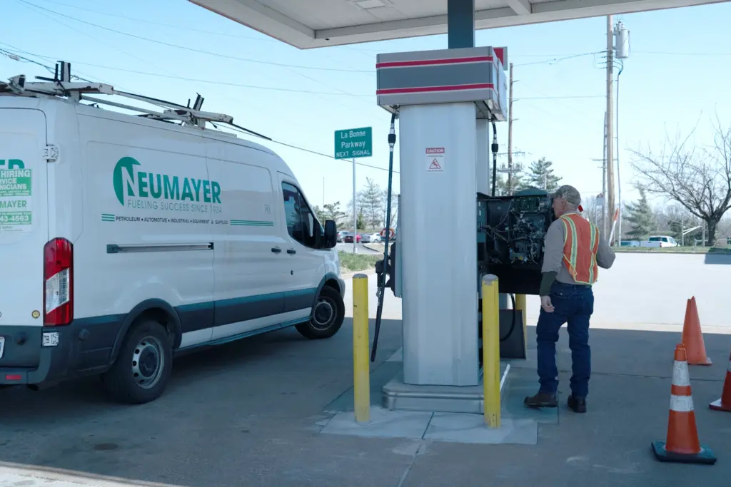 Neumayer employee working at gas pump with a Neumayer van at the next pump.