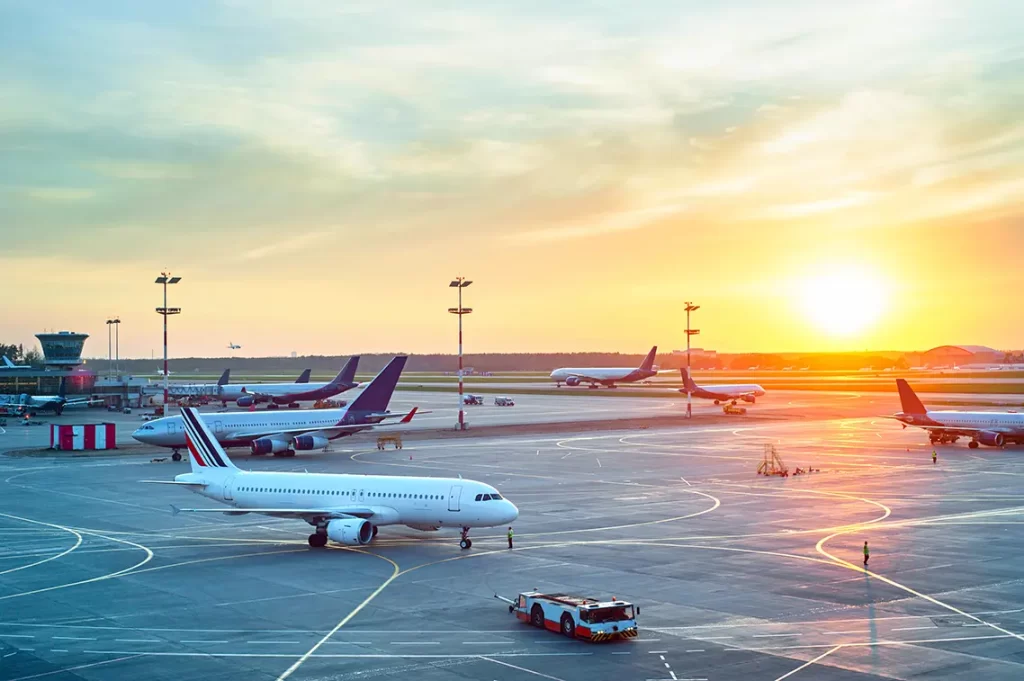 Planes at an airport during sunset.