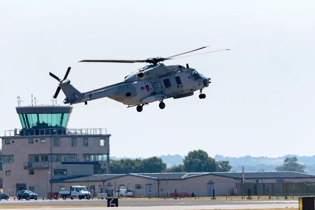 Marine helicopter passing a control tower on an airfield